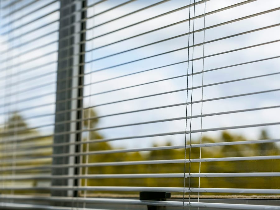 Persiana de aluminio de lamas horizontales instalada en una ventana