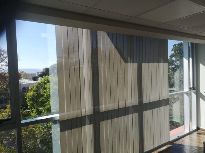 Cortinas verticales instaladas en una oficina con vista panorámica
