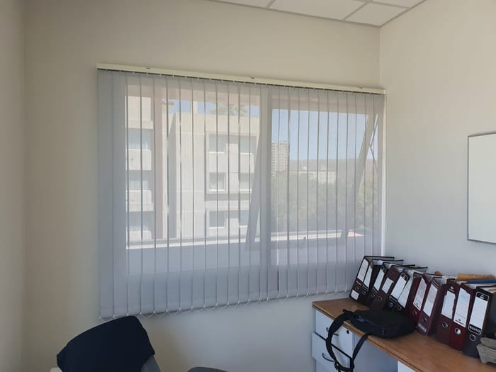 Cortinas verticales en una oficina con puesto de trabajo